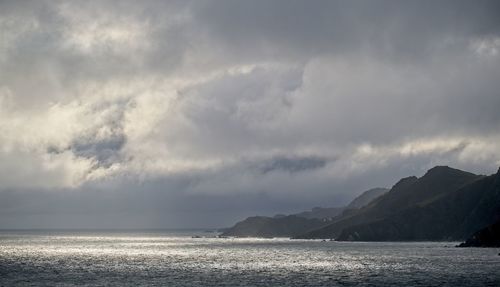 Scenic view of sea against sky with clouds and brewing storm