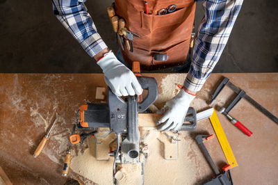 Midsection of man working at workshop