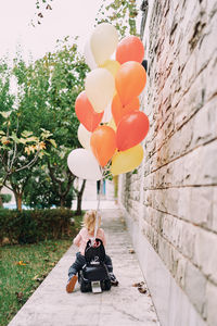 Rear view of woman with balloons in park