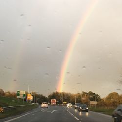 Rainbow over road in rain