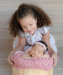 Portrait of cute newborn with a 6 years old sister 