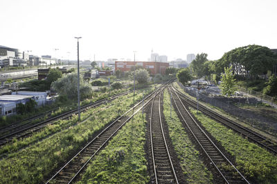 High angle view of railroad tracks amidst buildings against clear sky