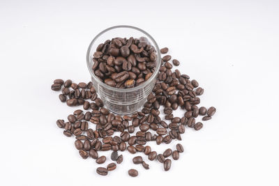 High angle view of coffee beans against white background