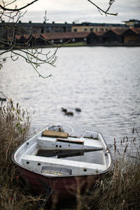 Sailboats moored on lake against sky