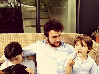 Father and daughter sitting on window