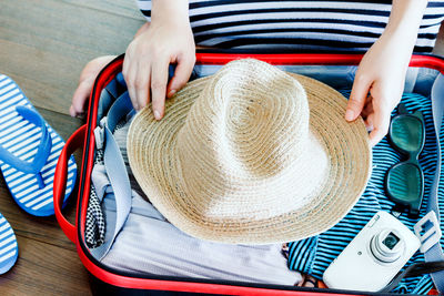 Low section of woman packing suitcase