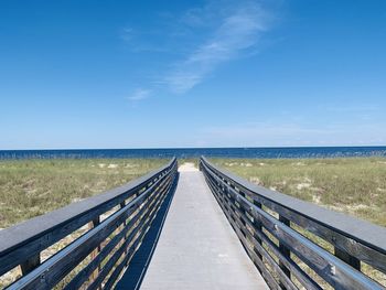 Bridge over sea against blue sky