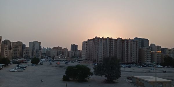 Buildings in city against sky during sunset