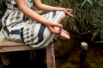 Young woman in dress meditating on the nature person