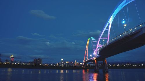 Suspension bridge over river at dusk