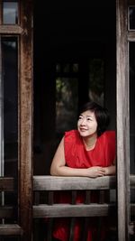Portrait of smiling young woman sitting on wood