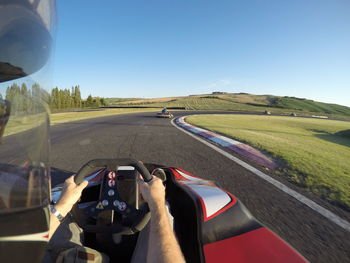 Man driving car on road against clear sky