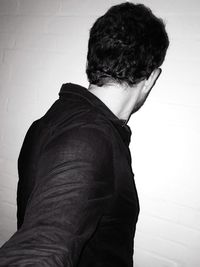 Rear view of man standing against wall