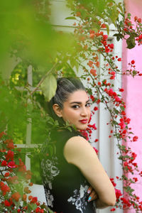 Young woman standing amidst plants