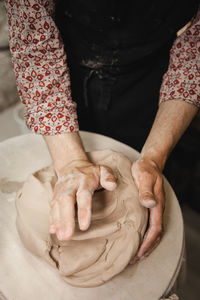 Midsection of man making pot