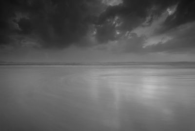 Scenic view of sea against storm clouds