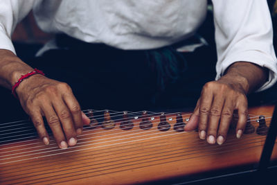 Midsection of man playing string instrument