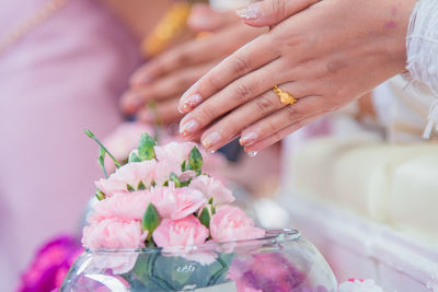 Close-up of hand holding bouquet of red flower