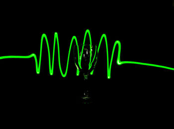 Close-up of illuminated lights over black background