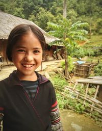 Portrait of smiling girl standing against plants