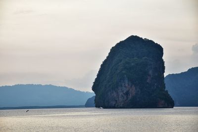 Rock formation in sea against sky