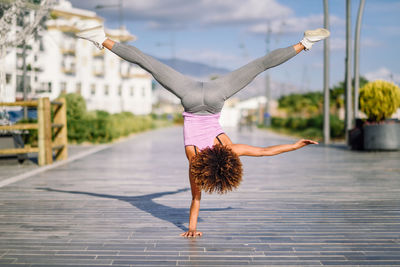 Young woman exercising on footpath