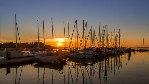 Sailboats in sea at sunset