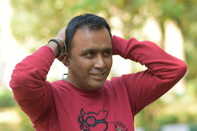 Portrait of young man looking away while standing outdoors