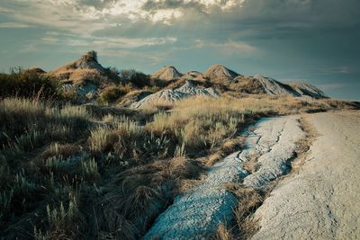 Scenic view of tuscany clay hills against dramatic sky