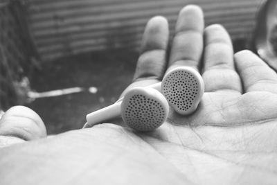 Cropped hand holding in-ear headphones