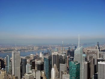 Modern buildings in city against clear blue sky