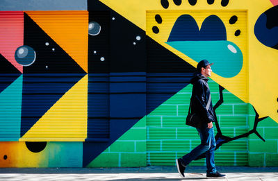 Full length of woman walking on yellow umbrella