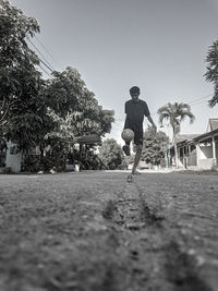 Rear view of man on footpath against clear sky