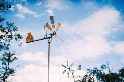 Low angle view of weather vane against sky