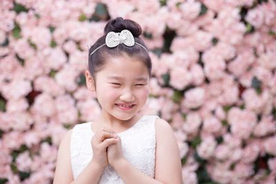 Close-up of cute girl against flowers