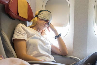 Mid adult woman sleeping at airplane
