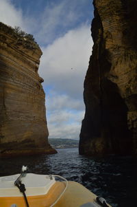 Rock formations by sea against sky