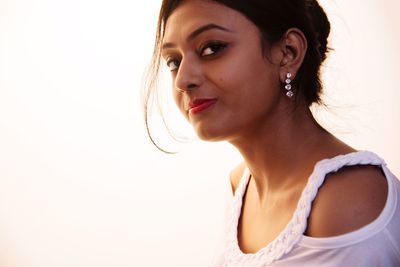 Portrait of young woman against clear sky during sunset