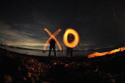 Illuminated traditional windmill against sky at night