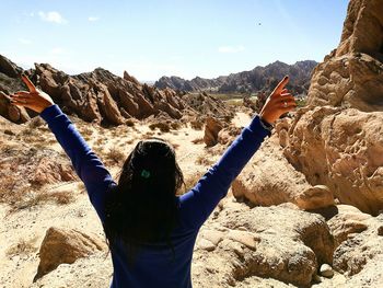 Rear view of woman standing on rock