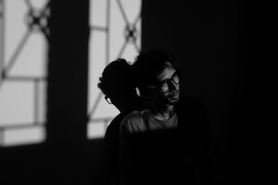 Man sitting against wall in darkroom