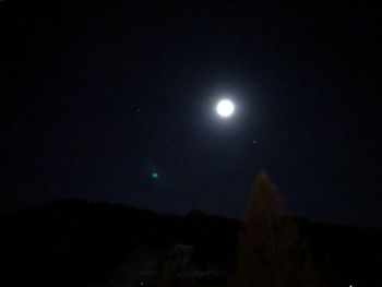 Low angle view of illuminated moon against sky at night