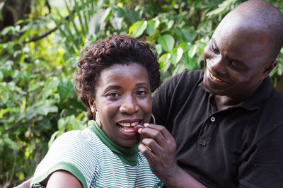 Happy man gives a fruit to eat to his girlfriend during a picnic