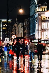 People walking on wet street during rainy season