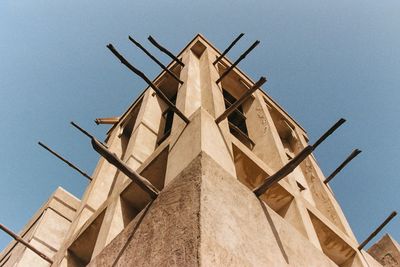 Low angle view of traditional windmill against clear blue sky