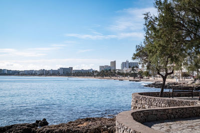 Scenic view of sea by buildings against sky