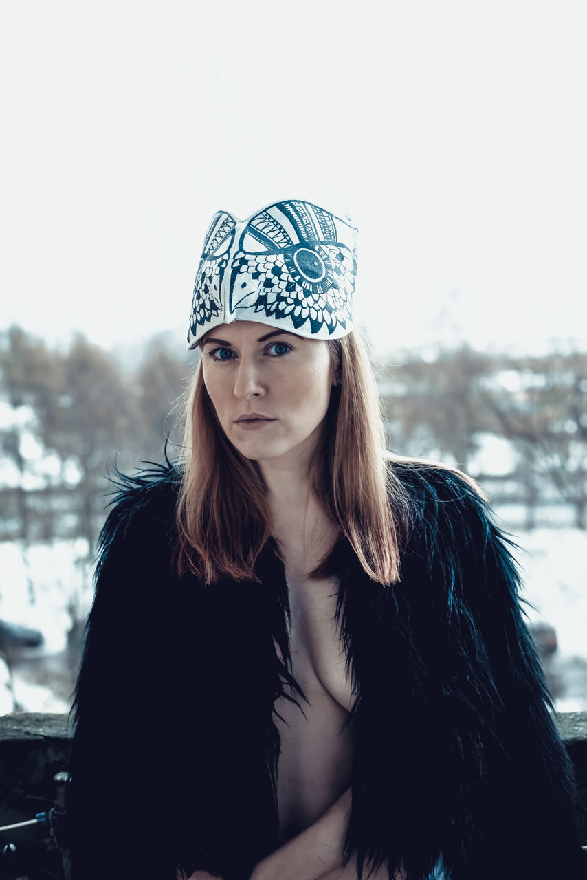 PORTRAIT OF YOUNG WOMAN WEARING HAT