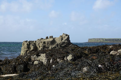 Panoramic view of rocks on beach against sky