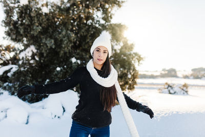 Portrait of young woman standing in snow