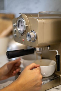 Cropped hands of woman pouring coffee in cup